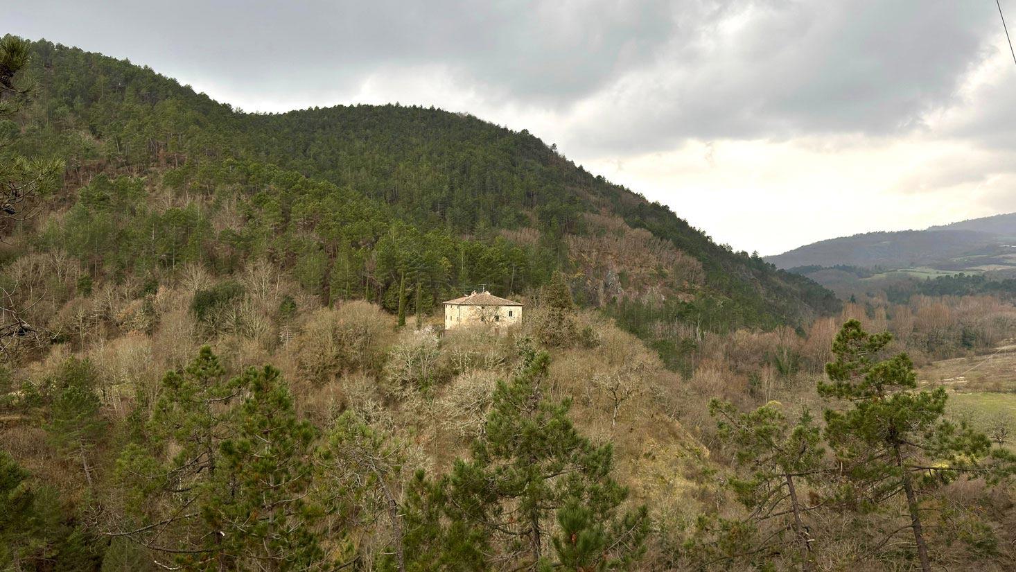 Il Conventino on its forested hillside, viewed from across the valley