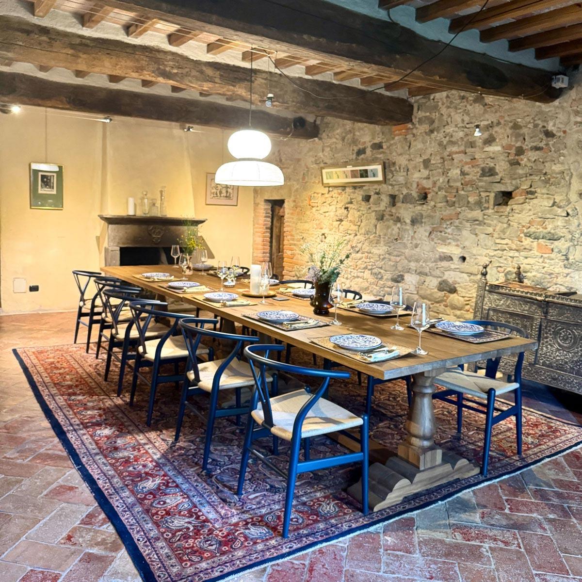 The refectory restored as a dining hall, blue wishbone chairs around a long wooden table