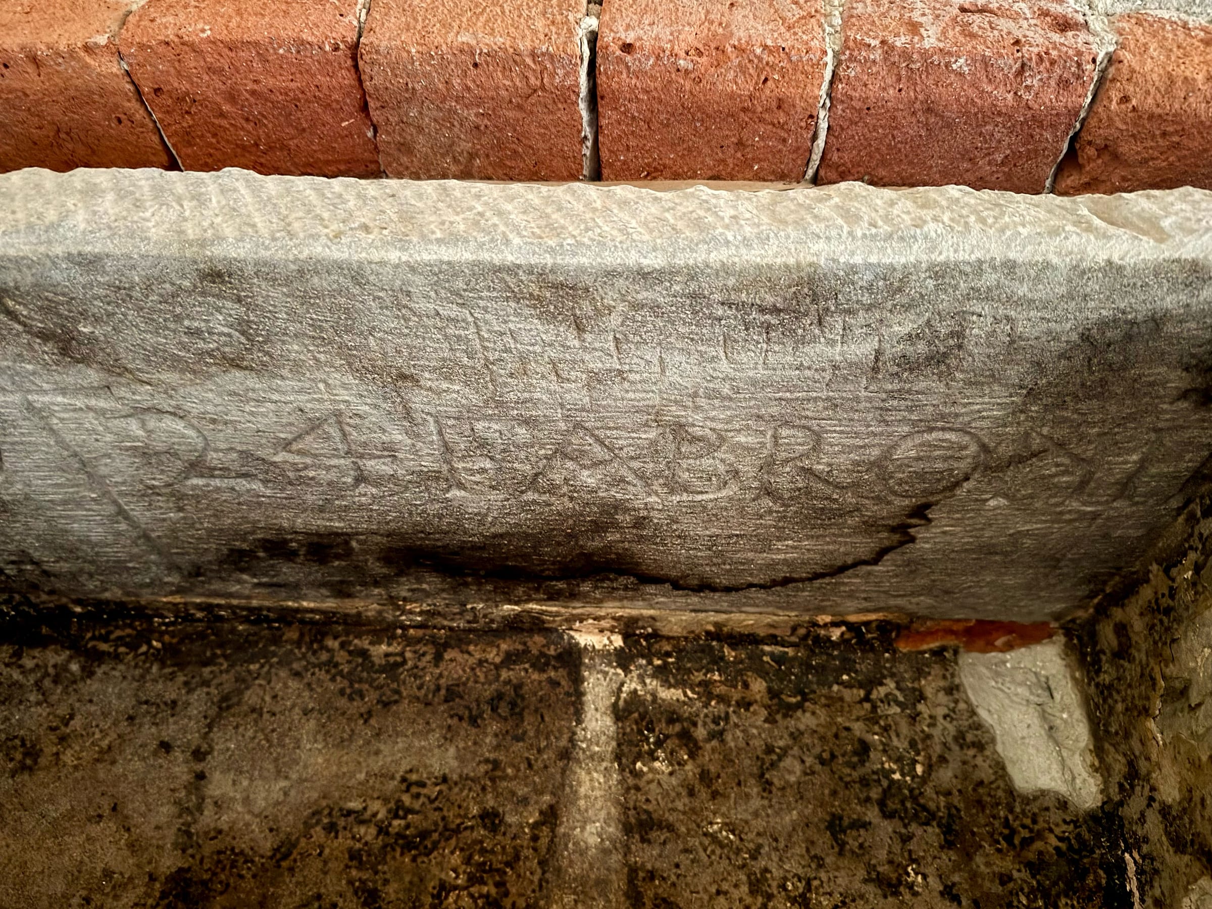 Weathered stone lintel carved with the name Fabroni, beneath a course of old brick